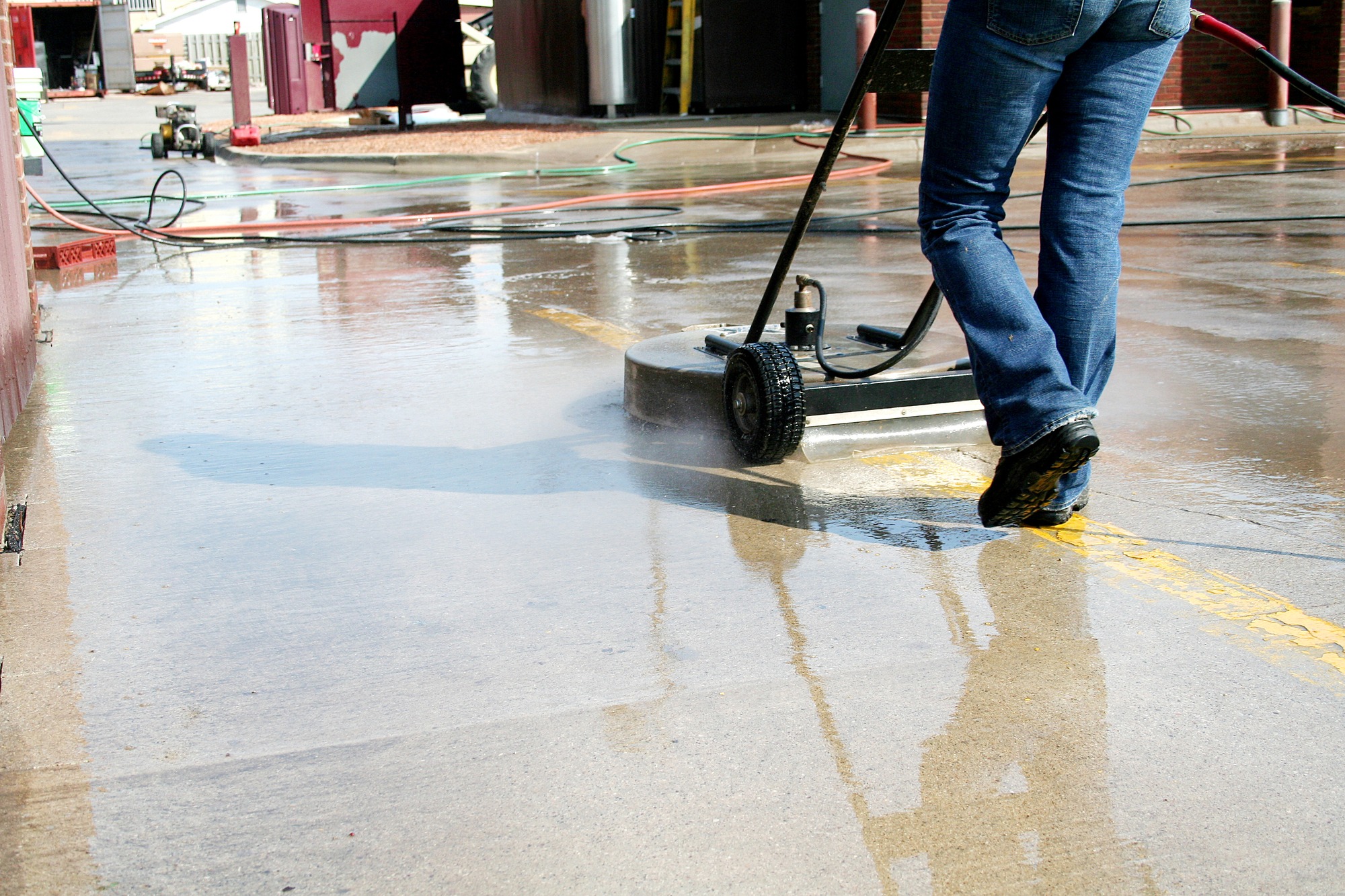 A man cleaning on a parking lot by using a machine